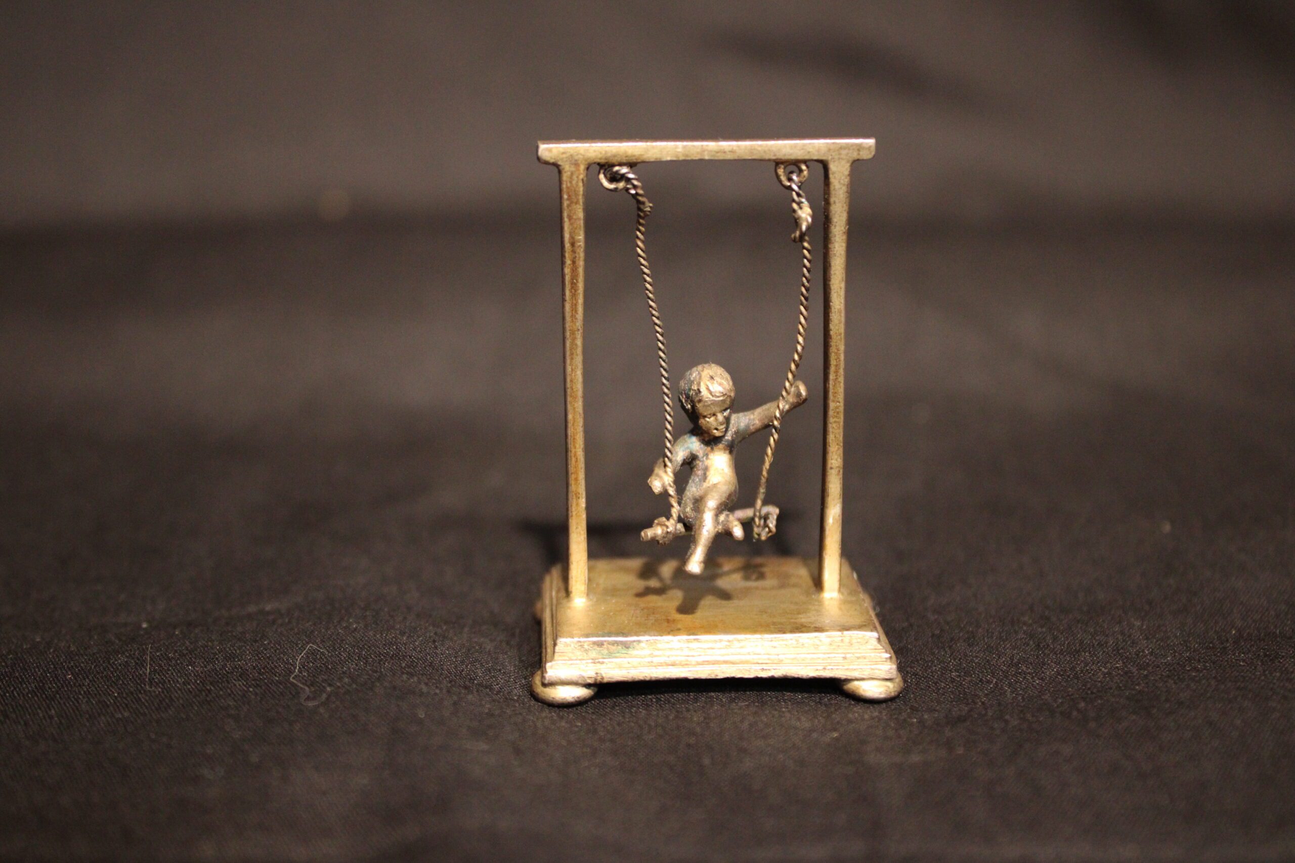 Dutch Figural Miniature Of A Child On A Swing 20th C.
